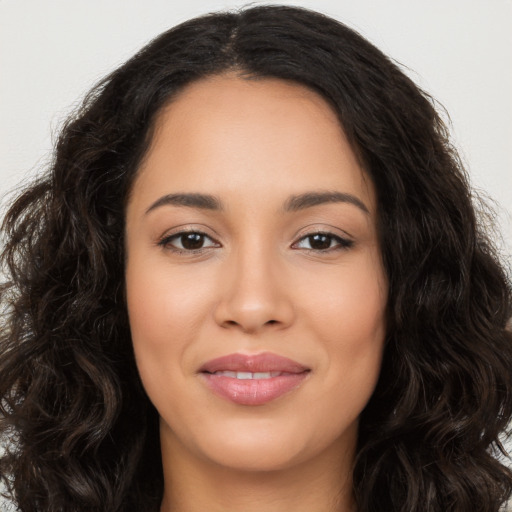 Joyful latino young-adult female with long  brown hair and brown eyes