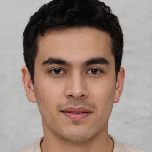 Joyful latino young-adult male with short  black hair and brown eyes