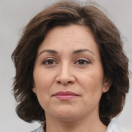 Joyful white adult female with medium  brown hair and brown eyes