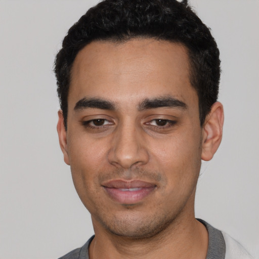 Joyful latino young-adult male with short  black hair and brown eyes