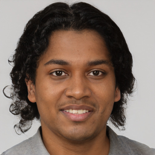 Joyful black young-adult male with short  black hair and brown eyes