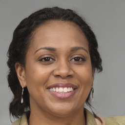 Joyful black adult female with medium  brown hair and brown eyes