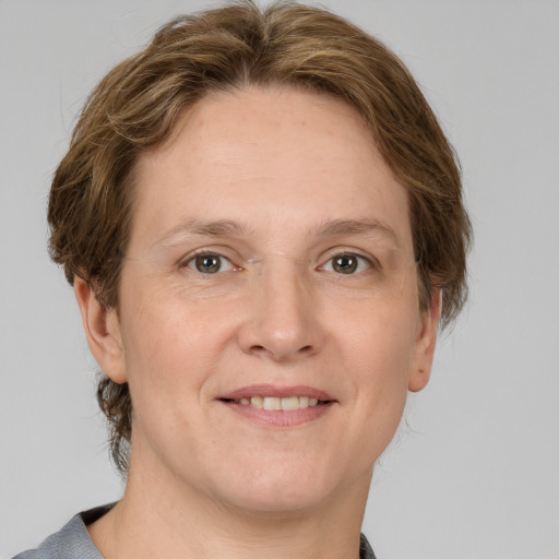 Joyful white adult female with medium  brown hair and grey eyes