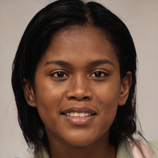 Joyful black young-adult female with long  brown hair and brown eyes