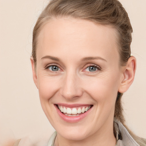 Joyful white adult female with long  brown hair and grey eyes