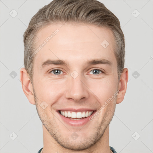 Joyful white young-adult male with short  brown hair and grey eyes