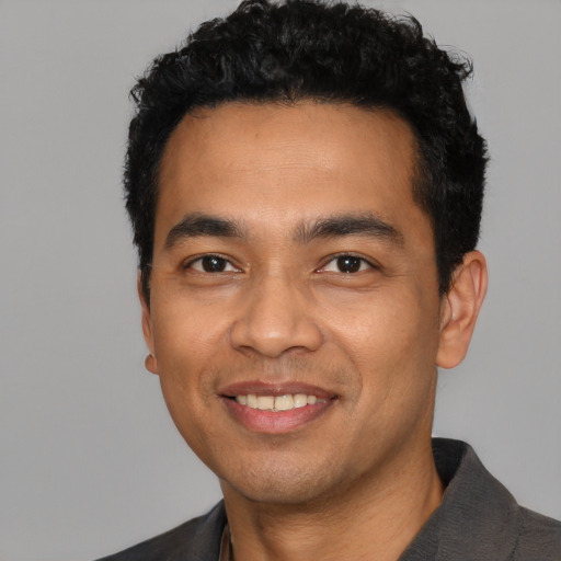 Joyful latino young-adult male with short  black hair and brown eyes