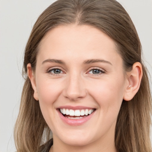 Joyful white young-adult female with long  brown hair and grey eyes