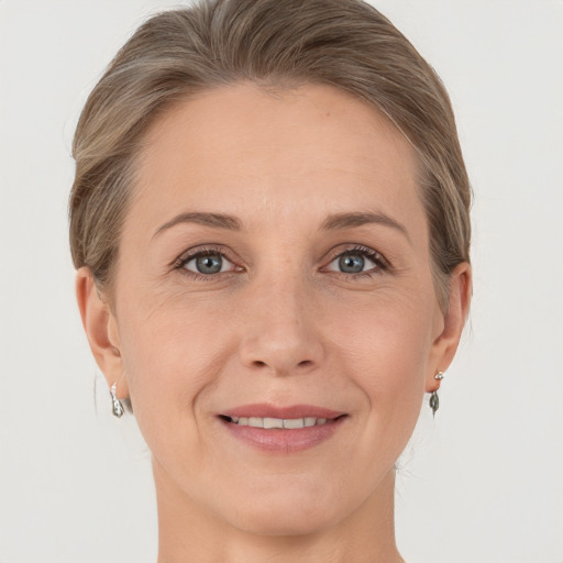 Joyful white adult female with medium  brown hair and grey eyes