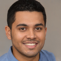 Joyful latino young-adult male with short  brown hair and brown eyes