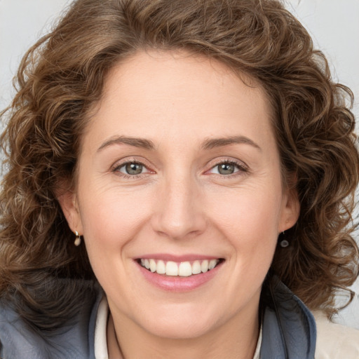 Joyful white young-adult female with long  brown hair and green eyes