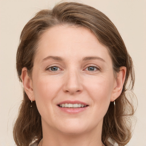 Joyful white young-adult female with medium  brown hair and grey eyes