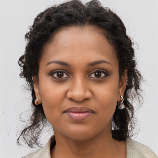 Joyful black young-adult female with long  brown hair and brown eyes