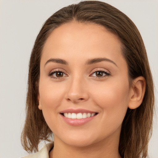 Joyful white young-adult female with long  brown hair and brown eyes