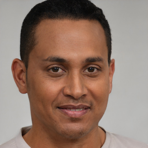 Joyful latino young-adult male with short  brown hair and brown eyes