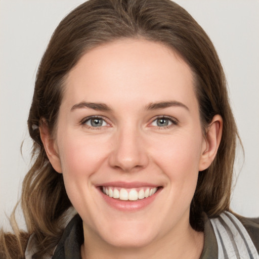 Joyful white young-adult female with medium  brown hair and grey eyes