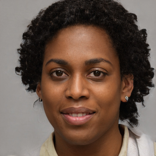 Joyful black young-adult female with long  black hair and brown eyes