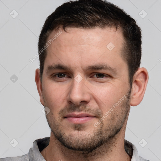 Joyful white young-adult male with short  brown hair and brown eyes