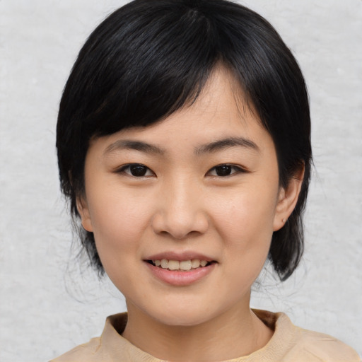 Joyful asian young-adult female with medium  black hair and brown eyes