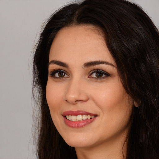 Joyful white young-adult female with long  brown hair and brown eyes