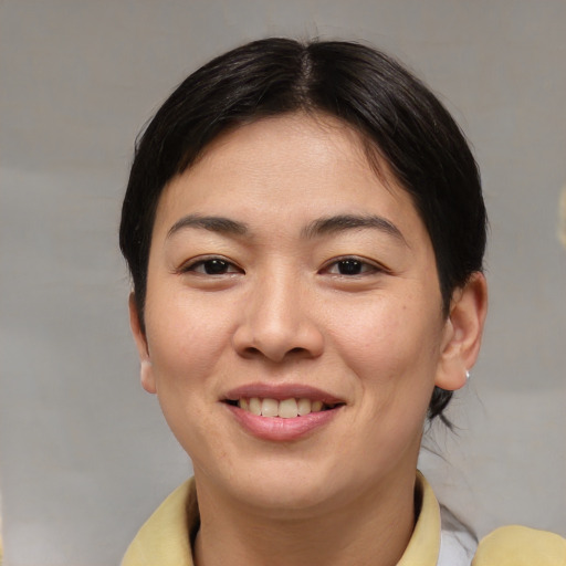 Joyful asian young-adult female with short  brown hair and brown eyes