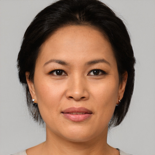 Joyful asian adult female with medium  brown hair and brown eyes