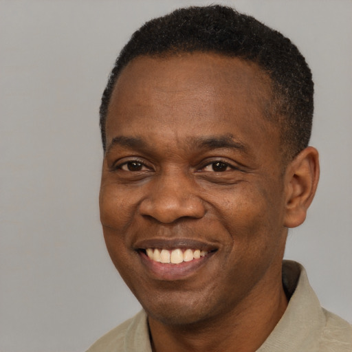 Joyful black adult male with short  brown hair and brown eyes