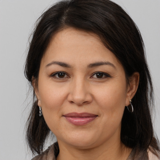 Joyful latino adult female with medium  brown hair and brown eyes