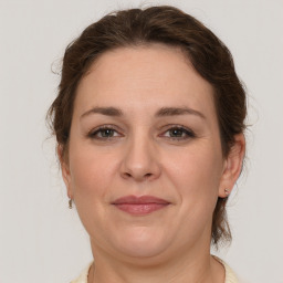 Joyful white adult female with medium  brown hair and grey eyes