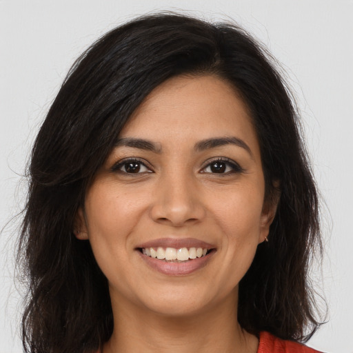 Joyful latino young-adult female with long  brown hair and brown eyes