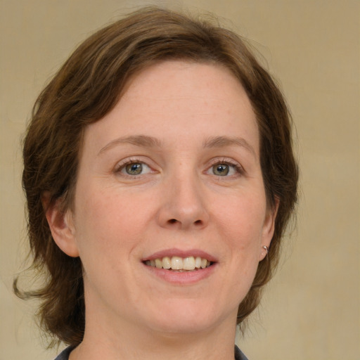 Joyful white adult female with medium  brown hair and green eyes