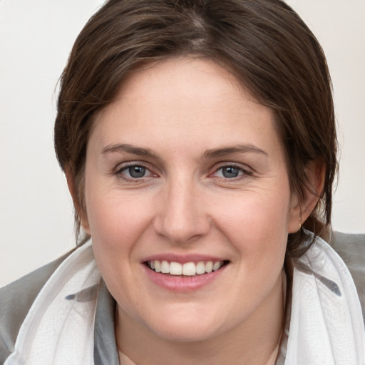 Joyful white young-adult female with medium  brown hair and grey eyes