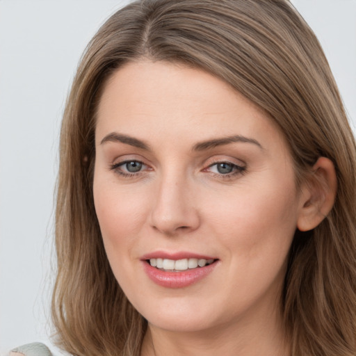 Joyful white young-adult female with long  brown hair and blue eyes