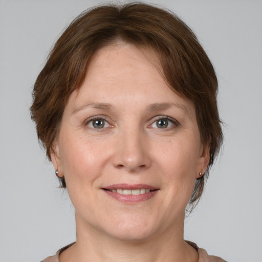 Joyful white adult female with medium  brown hair and grey eyes