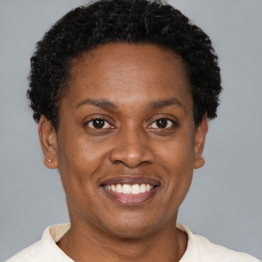 Joyful black young-adult female with short  brown hair and brown eyes