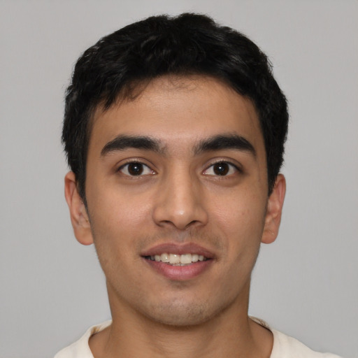 Joyful latino young-adult male with short  black hair and brown eyes