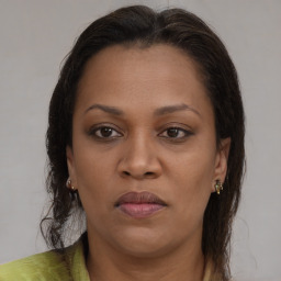 Joyful black young-adult female with long  brown hair and brown eyes
