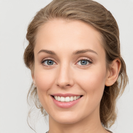 Joyful white young-adult female with medium  brown hair and green eyes