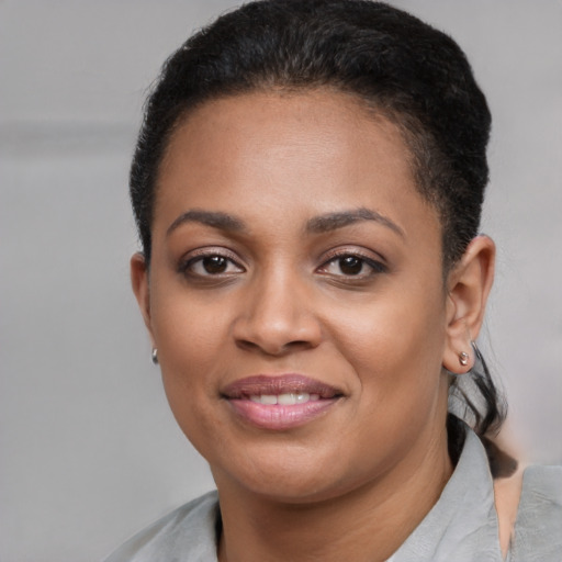 Joyful black young-adult female with short  black hair and brown eyes