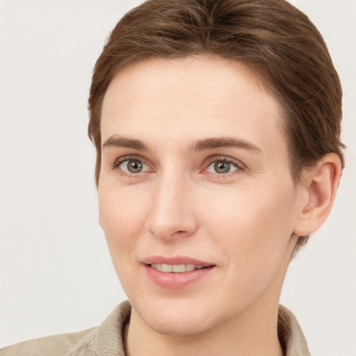 Joyful white young-adult female with short  brown hair and grey eyes