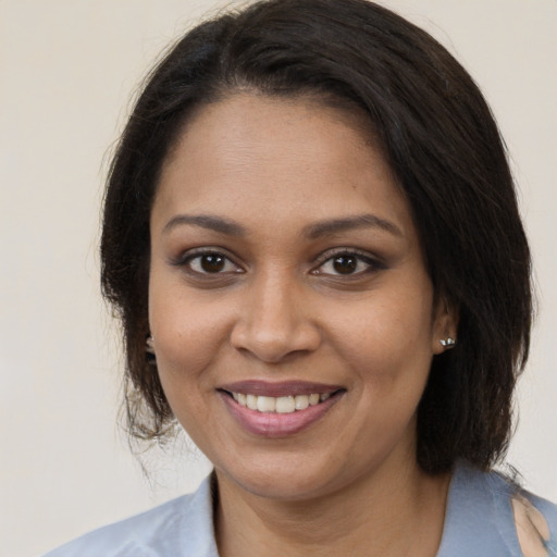 Joyful black young-adult female with medium  brown hair and brown eyes