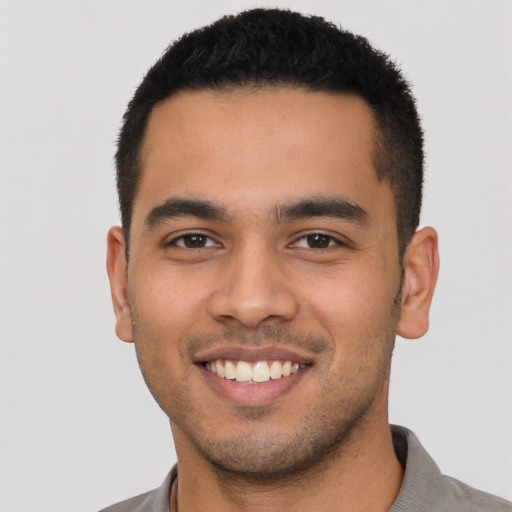 Joyful latino young-adult male with short  brown hair and brown eyes