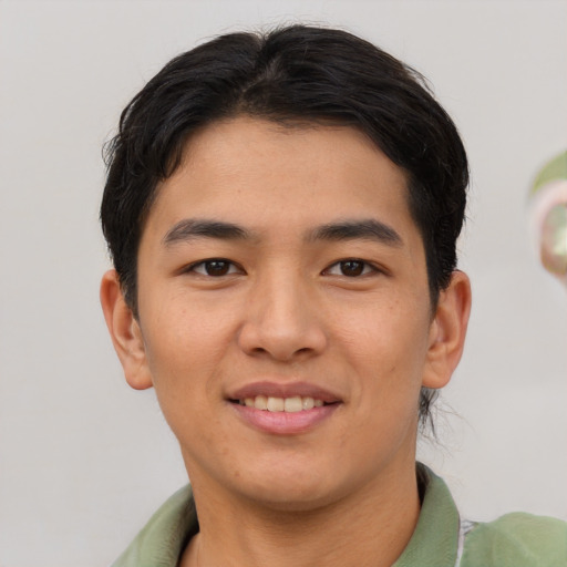Joyful asian young-adult male with short  brown hair and brown eyes