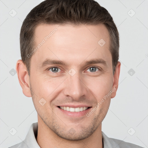 Joyful white young-adult male with short  brown hair and grey eyes