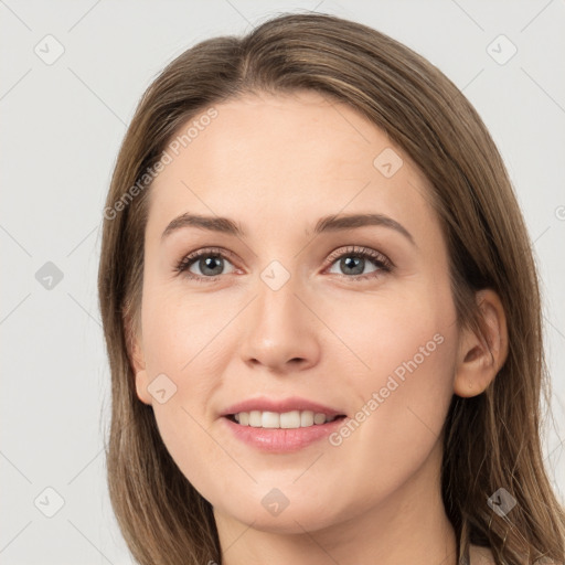 Joyful white young-adult female with long  brown hair and grey eyes