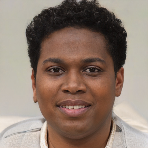 Joyful black young-adult male with short  brown hair and brown eyes