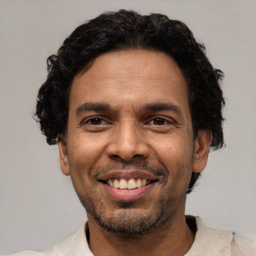 Joyful latino adult male with short  black hair and brown eyes