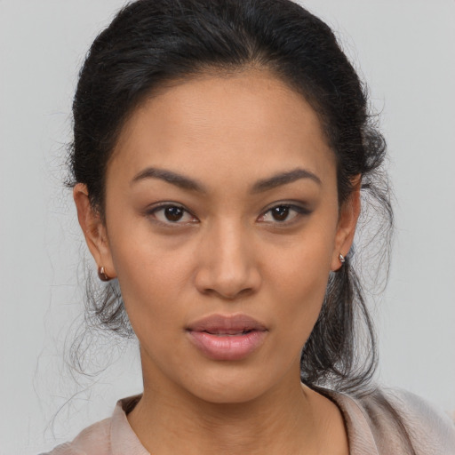 Joyful latino young-adult female with long  brown hair and brown eyes