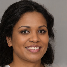 Joyful black young-adult female with long  brown hair and brown eyes