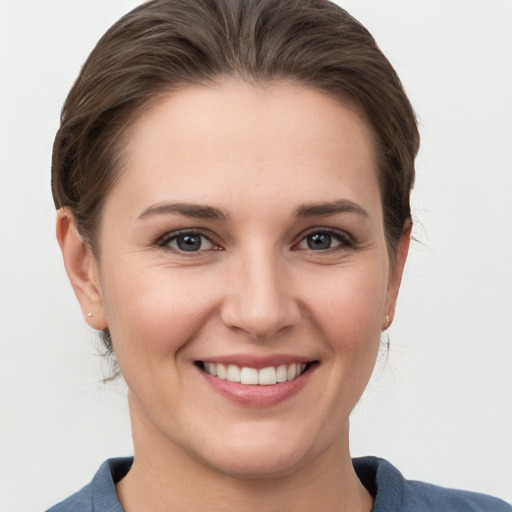 Joyful white young-adult female with medium  brown hair and grey eyes